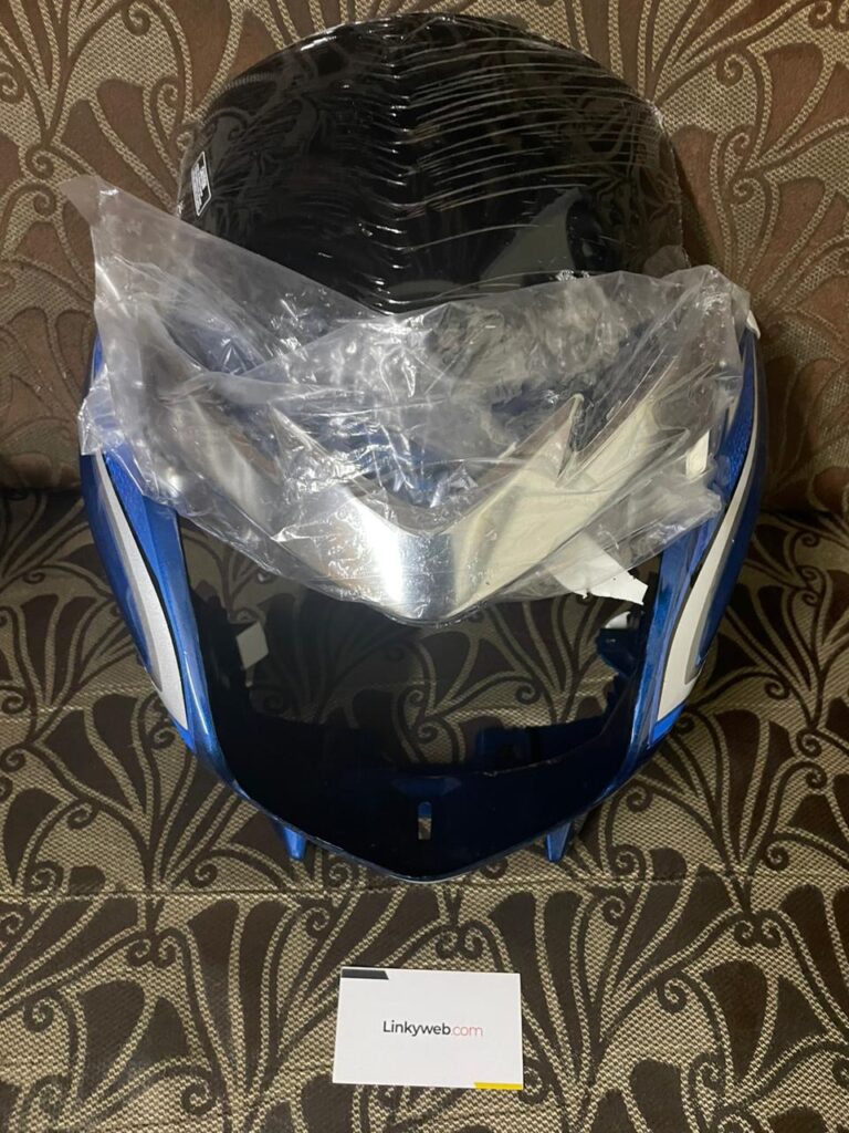 Blue honda shine visor resting on a clean surface showcasing its fiber build.