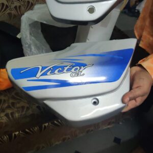 A brand new tvs victor side panel with matching red stickers ready for motorcycle installation