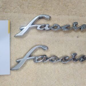 Close-up view of shiny yamaha fascino logos packaged for easy installation.