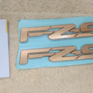 Close-up view of the premium yamaha fz s golden logo accessory for motorcycles
